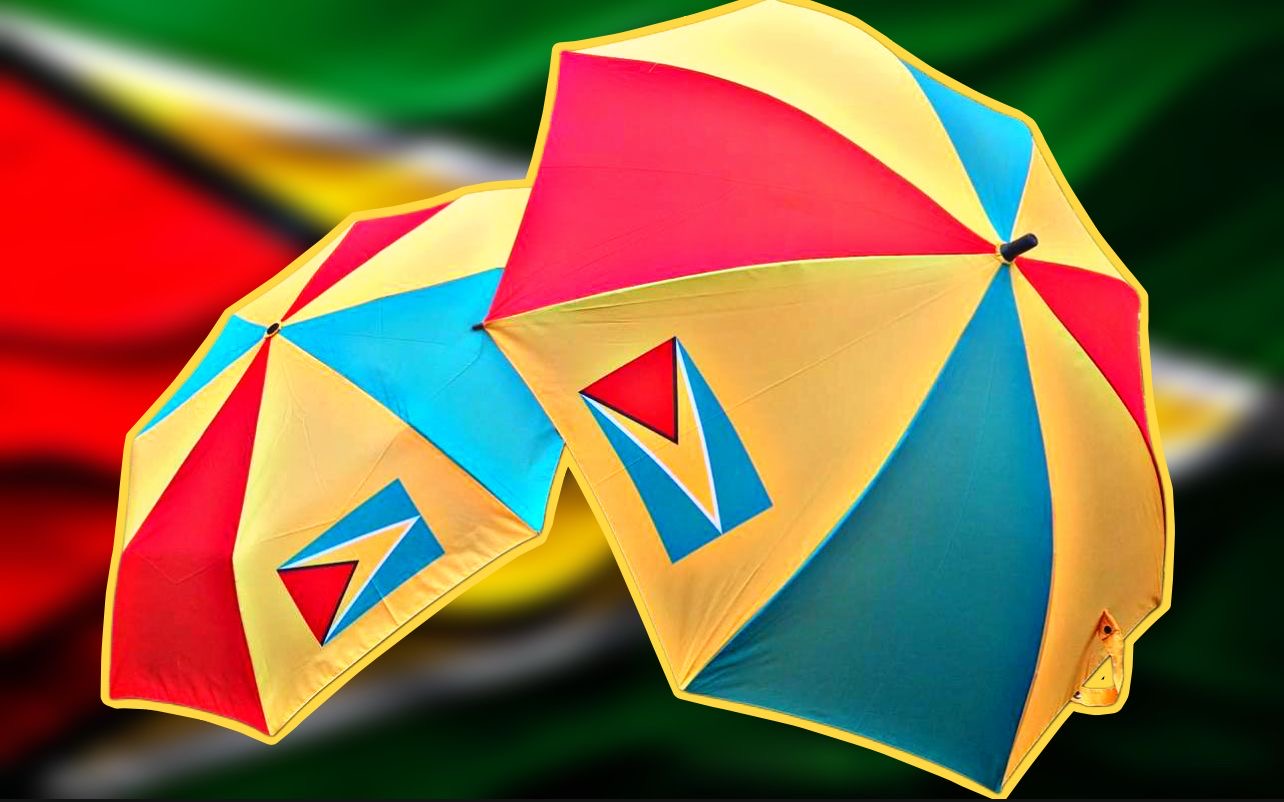 Colorful Guyana umbrella with blue, yellow, and red design, featuring a unique logo for Brollies Unique Ltd